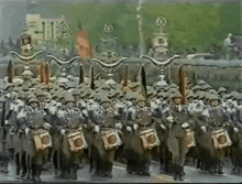 a large group of soldiers marching down a street carrying drums