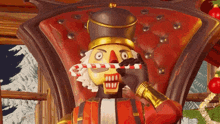a nutcracker is sitting in a chair holding a candy cane .