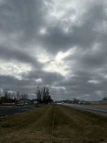 the sun is shining through the clouds over a road