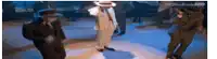 a man in a white suit and hat is dancing on a dance floor with other men .
