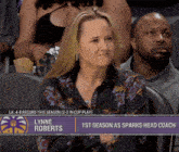 a woman sits in the stands watching a basketball game with the name lynne roberts