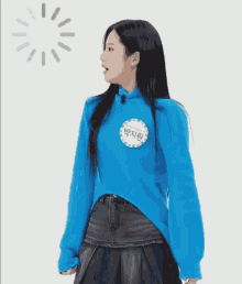 a girl wearing a blue sweater has a name tag that says " 박지원 "