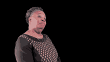 a woman in a black dress with a diamond pattern on the top