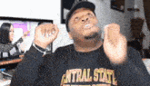 a man wearing a central state shirt is making a funny face