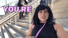 a woman standing on stairs with the word you 're above her head