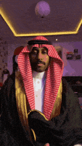a man with a red and white head scarf on his head