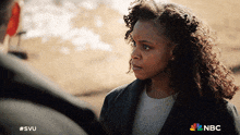 a woman looking at a man with the nbc logo on the bottom