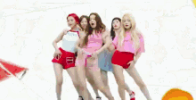 a group of girls are dancing together in front of a watermelon .