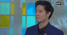 a man in a blue suit is standing in front of a stained glass window with the number 31 on the bottom