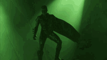 a man in a superhero costume stands in a green room