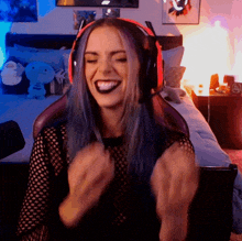 a woman with blue hair is wearing headphones and a black shirt