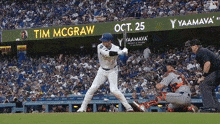 a baseball player is swinging at a ball in front of a sign that says tim mcgraw