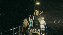 a group of people standing on a stage with one wearing a shirt that says reebok