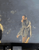 a blurry picture of a person standing in front of a crowd at a stadium .