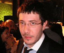 a man with glasses and a beard is standing in a crowd