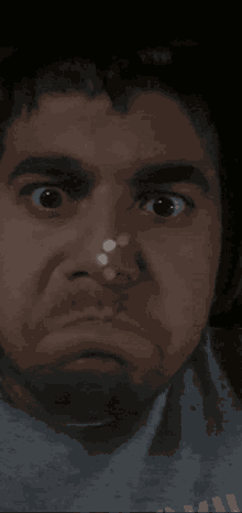 a close up of a man 's face with a slight smirk on his face