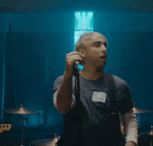 a man singing into a microphone while another man plays a guitar
