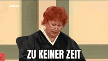 a judge with red hair and glasses is sitting in a courtroom with the words zu keiner zeit written on the screen .