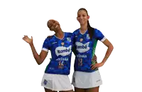 two female athletes are posing for a picture and one has the number 18 on her jersey