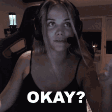 a woman wearing headphones and a black tank top is asking the question " okay "