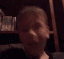 a close up of a person 's face with their mouth open and a blurred background .