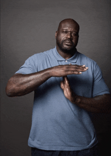 a man in a blue shirt holds his hands together