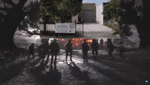 a group of zombies are walking in front of a workshop 26 sign
