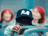 a man wearing a baseball cap with chinese writing on it