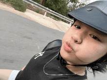 a young boy wearing a helmet and a ny shirt looks at the camera