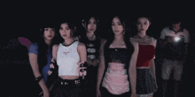 a group of girls standing in a dark room with a man holding a flashlight