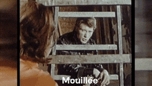 a man and a woman are looking through a wooden fence and the word mouillee is on the bottom