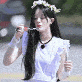 a girl with a flower crown blowing bubbles