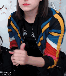 a woman wearing a colorful jacket with the words dynamite twins on the bottom right