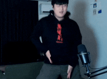 a man is dancing in front of a microphone in a room .