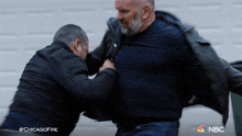 two men are fighting in a chicago fire scene
