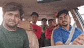 a group of young men are sitting in the back seat of a car and posing for a picture .