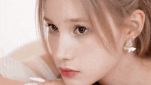 a close up of a woman 's face with a butterfly earrings