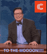 a man in a suit and bow tie is sitting at a desk with the words to the moooon written on it
