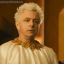 a man with white hair is wearing a white and gold dress