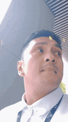 a man wearing a lanyard with the letter m on it looks up