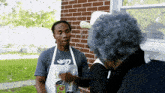a man wearing an apron that says " can it " talks to a woman