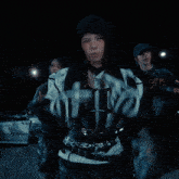 a woman in a hooded jacket is wearing a pair of gloves