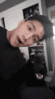 a man taking a selfie with a dog in the background