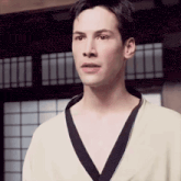 a man without a shirt is wearing a kimono and looking at the camera