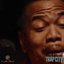 a close up of a man 's face with trap city written on the bottom