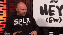 a man sitting in front of a sign that says " hey "