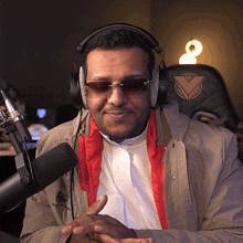 a man wearing headphones and sunglasses looks at the camera