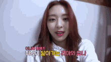 a woman with red hair is wearing a white sweatshirt with foreign writing on it