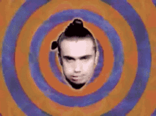 a man 's face is surrounded by colorful circles on a psychedelic background