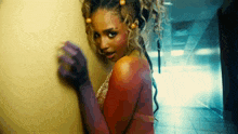 a woman with purple gloves on her hands is standing in a hallway .